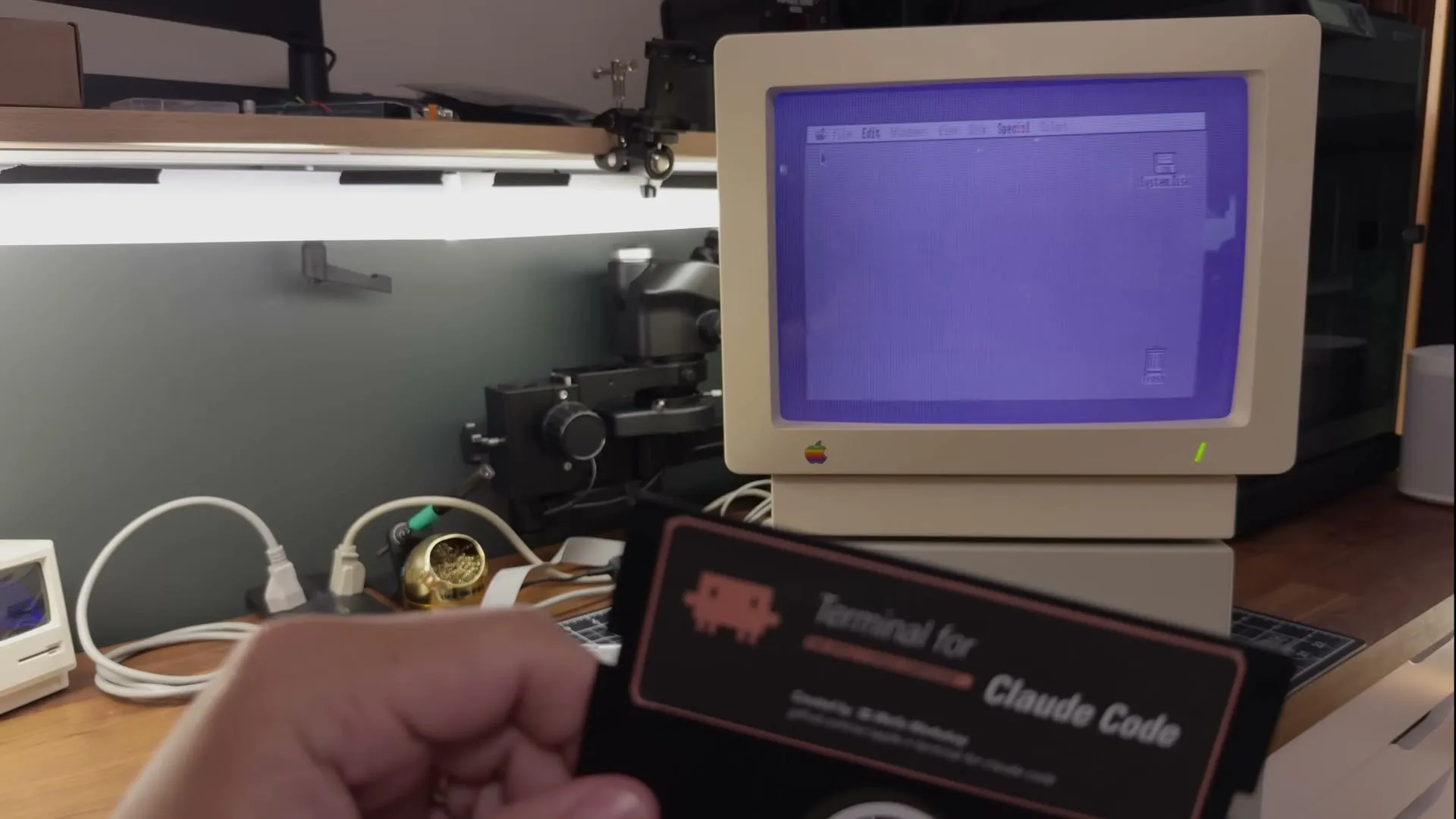 The Terminal for Claude Code floppy disk, held up in front of an Apple IIgs