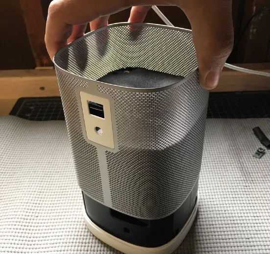 Lifting the metal grille off the speaker