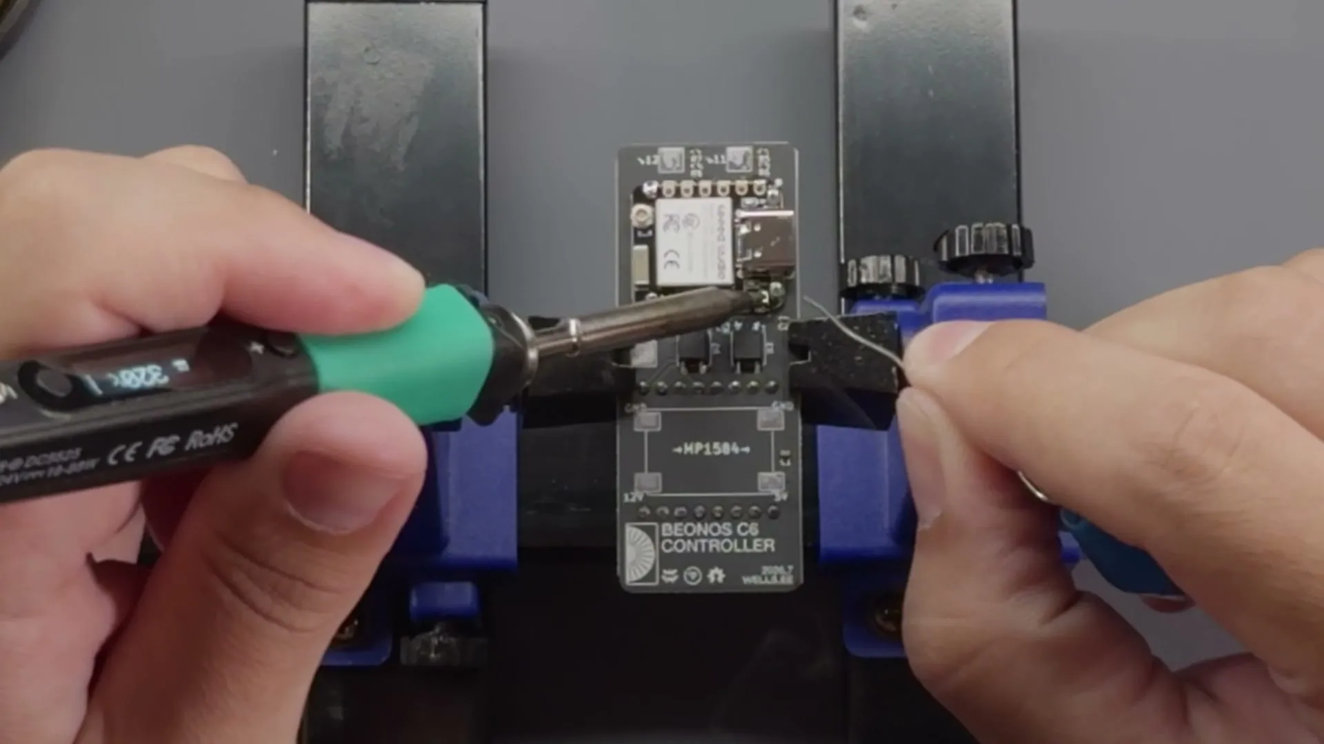Soldering a module onto a Beonos controller board held in a vise
