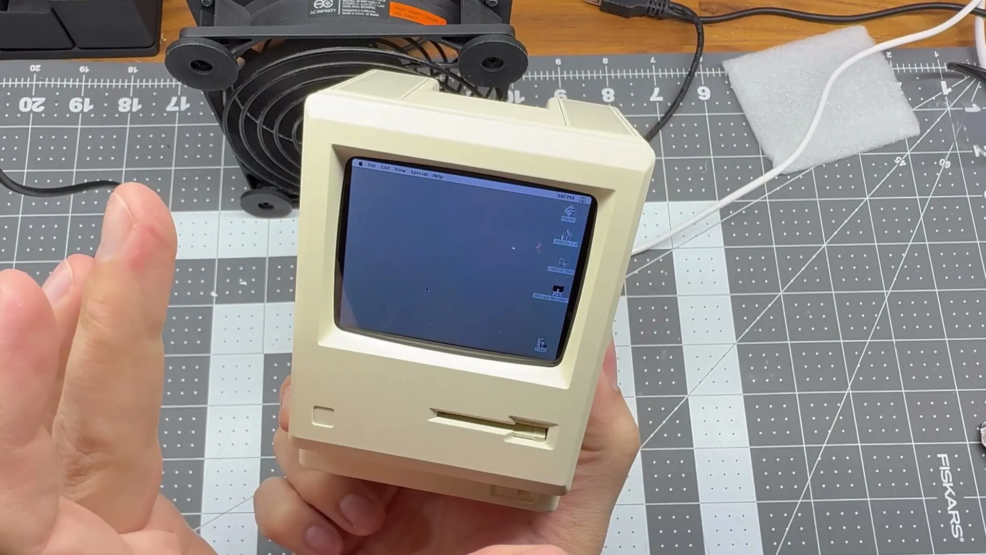 The Macintosh Mini closed up and switched on, showing the Mac desktop