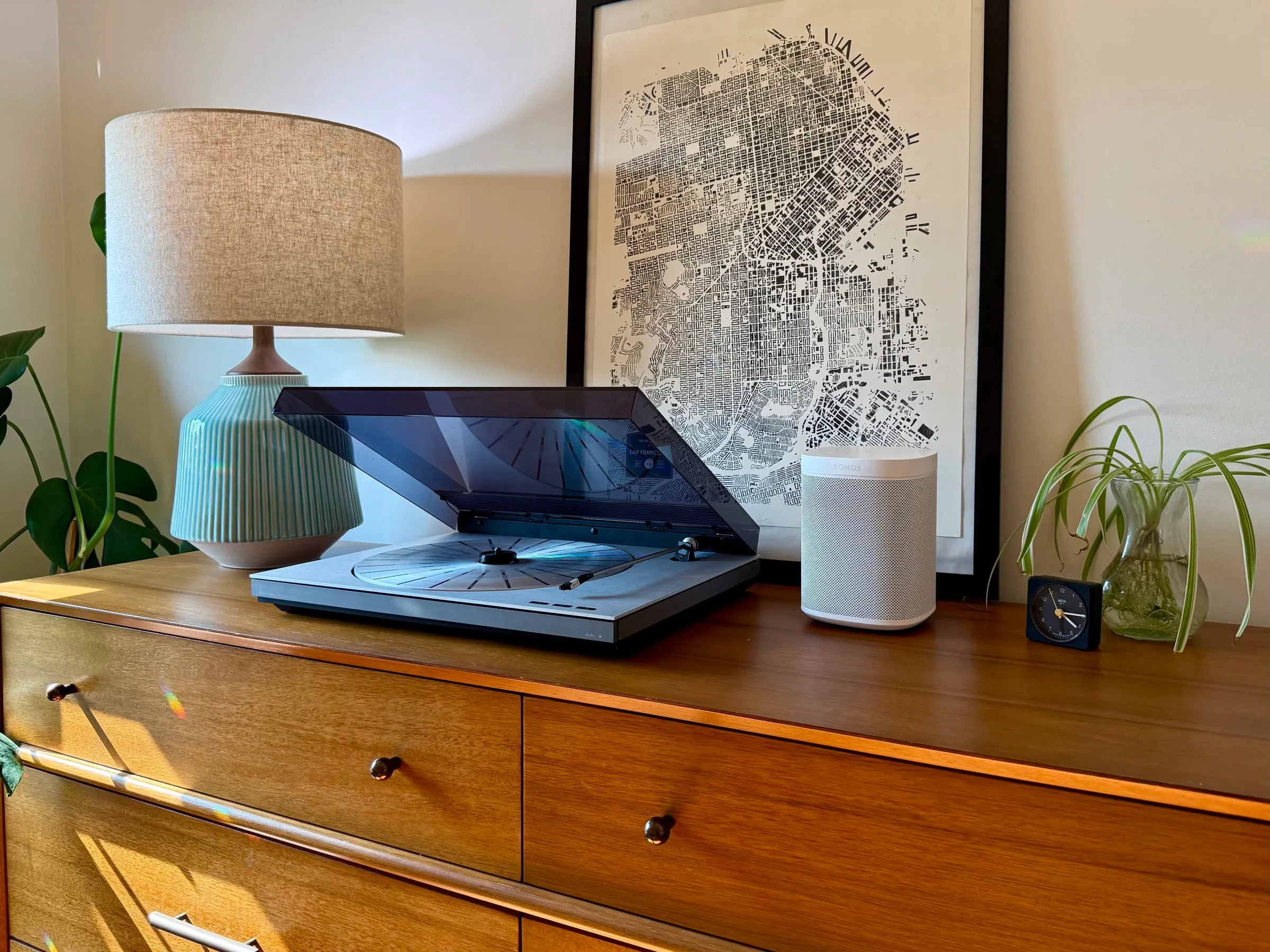 A Bang & Olufsen Beogram turntable on a dresser, beside a Sonos speaker
